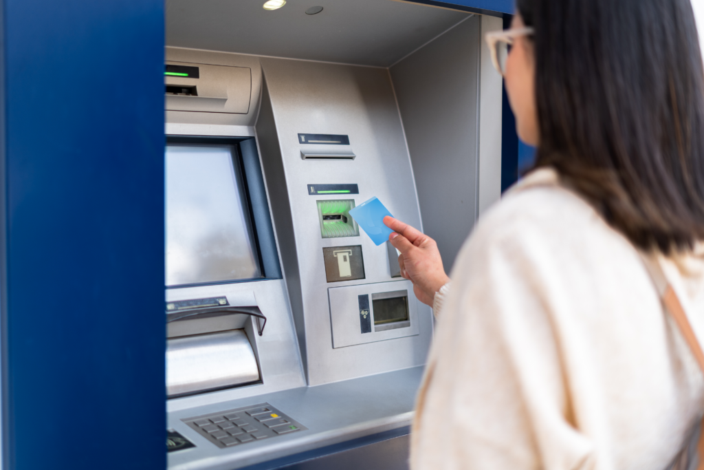 Person using their LCCU debit card at an ATM