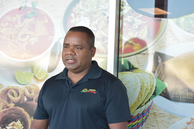 member Vicente standing outside his shop
