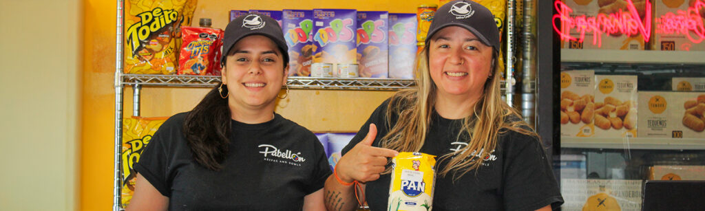 Members inside their business, wearing lccu har and holding products